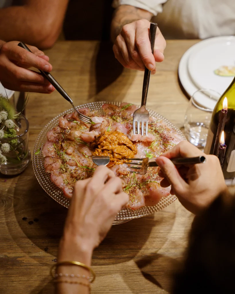 Plat de charcuterie et crème avec quatres personnes piochant avec leur fourchette