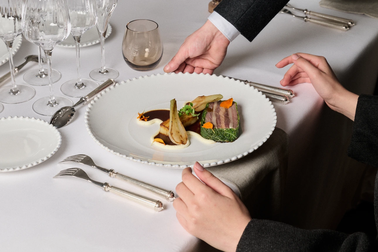 Assiette plat gastronomique servie par un serveur